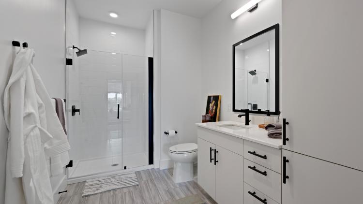 Bathroom with white vanity and glass-door shower