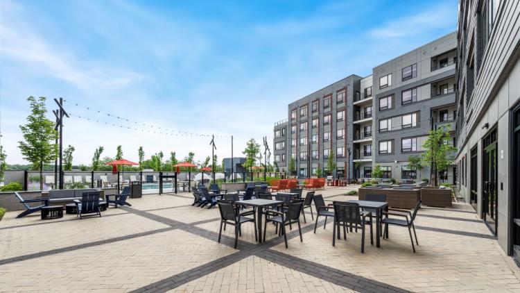 Outdoor courtyard with various tables and chairs with pool in background