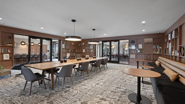 Large woodpaneled room with a conference table and smaller tables