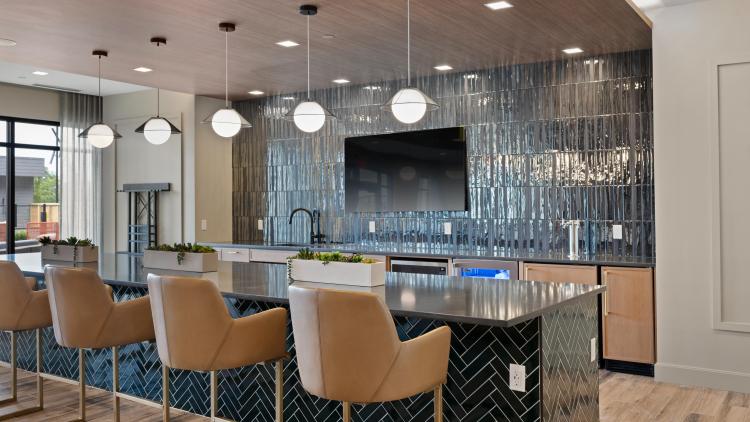 Bar with seating and a television hanging on the wall behind 