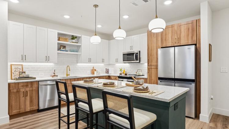 Kitchen with wood and white cabinets and a green island