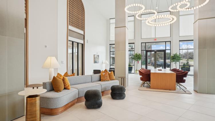 Bright lobby area with a couch and table and chairs