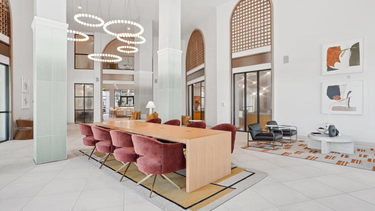Large bright lobby with long table and chairs and couch seating