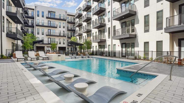 Outdoor pool surrounded by apartment building