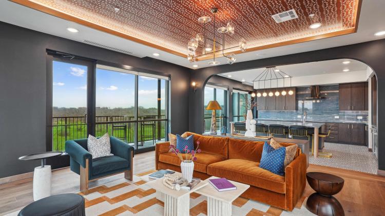 Lounge area with kitchen in background under arched opening