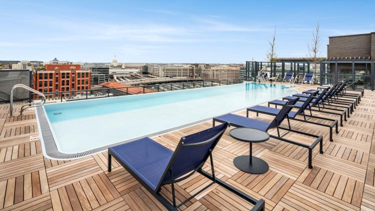 Outdoor pool with teak flooring and blue lounge chairs