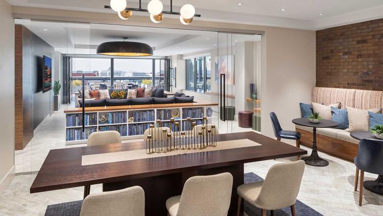 Room with mixed seating, including a table and chairs, booths, and sofas