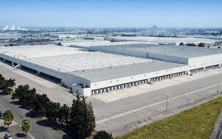 Aerial view of white warehouse with city landscapes in distance